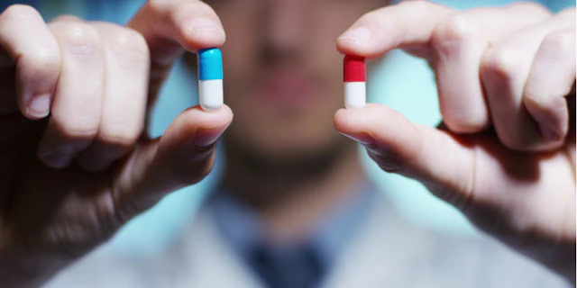 A doctor is holding two medicines in his hands.