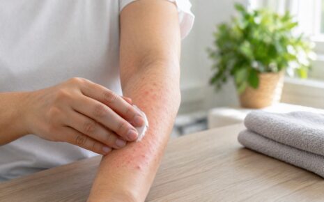 Person gently touching a mild skin rash on their forearm in a calm home setting
